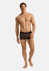 Boxer da uomo in marrone scuro, realizzati in tessuto liscio, con una vita elastica nera, forma aderente e gambe corte.