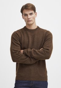 Brauner Pullover aus weicher Wolle, mit Rundhalsausschnitt, gerippten Bündchen und Saum. Der Stoff hat eine feine Textur und eine klassische Passform.