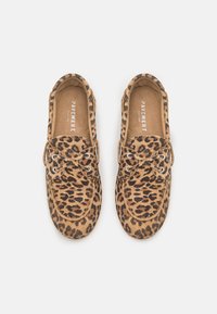 Mocassini in pelle scamosciata con stampa leopardo marrone e beige, dalla punta arrotondata, dettagli con lacci e una superficie testurizzata. Marchio visibile sulla soletta.
