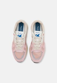 Athletic sneakers in pink suede and mesh with white accents, featuring beige laces, a colorful sole, and a blue logo on the insole.