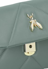 Clutch in pelle grigia trapuntata con un fermo in tonalità oro e un'emblema decorativo di un insetto. Texture liscia con dettagli di cucitura prominenti.