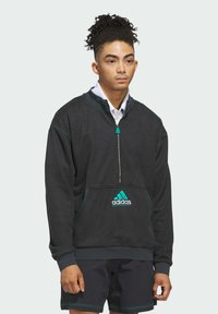 Felpa nera con zip, dettagli turchesi e logo, dotata di colletto alto, polsini elastici e tasca frontale. Texture liscia.
