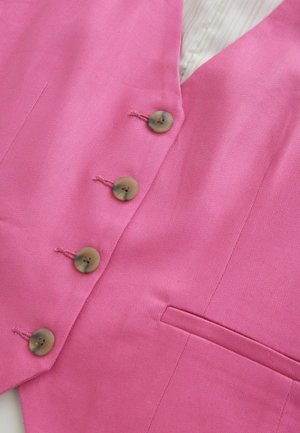 Pink vest made of textured fabric with four brown buttons and a small pocket. Lined with a subtle striped pattern. Tailored design.