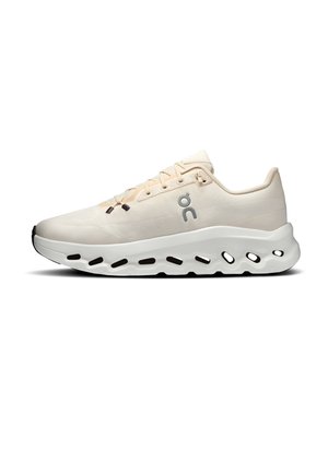 Béžová bežecká obuv s vrchnou časťou z priedušnej tkaniny, šnurovanie na šnúrky, odpružená podrážka s oválnymi výrezmi a logom značky na boku.