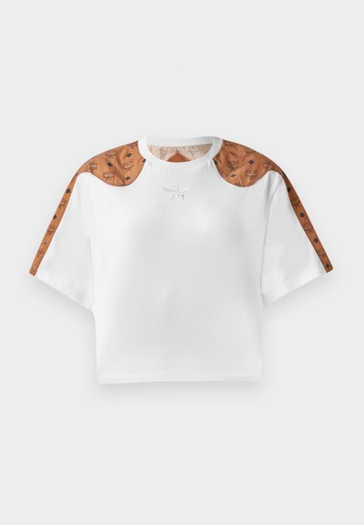 Kopta balta t-kreklu ar īsām piedurknēm, ar brūnu rakstainu detaļu uz pleciem un mazu sudraba logotipu priekšā.