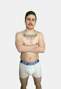 Boxer shorts bianchi con una cintura elastica blu sul quale è scritto "MR UKKO." Il tessuto appare morbido e aderente.