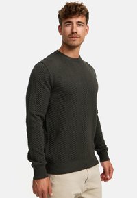 Dunkelgrüner Pullover aus strukturiertem Strickstoff, mit einem Zickzackmuster, gerippten Bündchen und Rundhalsausschnitt.