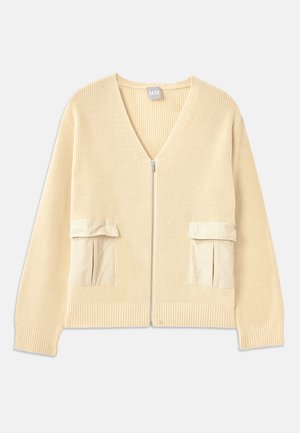 Cream knitted cardigan with a V-neck, front zipper, and two patch pockets. Features ribbed cuffs and hem, with smooth fabric accents.
