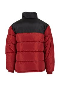 Giubbotto imbottito rosso e nero con colletto alto, dotato di cuciture orizzontali, polsini elastici e un design isolato.