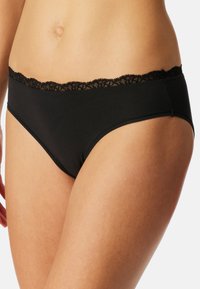 Culotte noire en coton avec une bordure en dentelle le long de la taille, présentant une texture lisse et un design taille basse.
