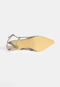 Sandale à talons hauts dorée avec un bout pointu, un design découpé, une fine bride de cheville et une semelle texturée avec un accent de talon carré.