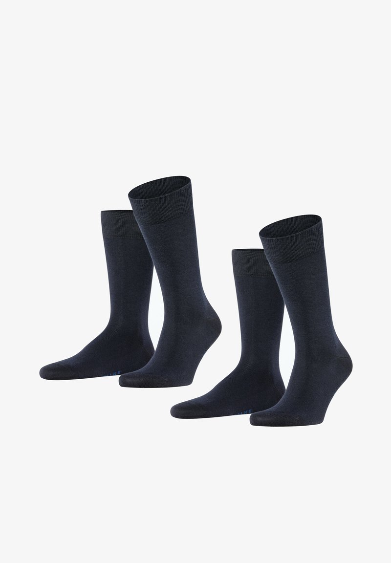 Calze di cotone blu scuro, con un bordo a coste, una texture liscia e una punta rinforzata, disposte in un gruppo di quattro paia.