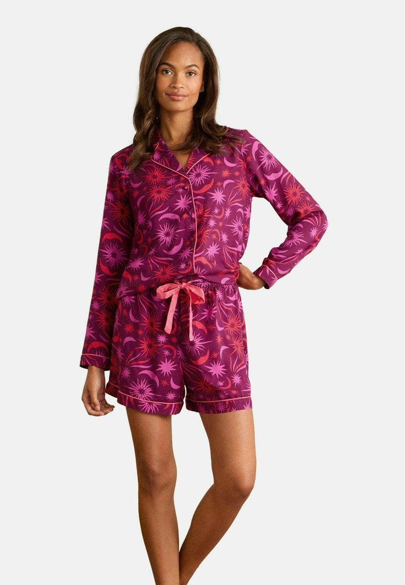 Set di pigiama a maniche corte e bottoni in un vivace viola con motivi floreali in rosa e corallo. Presenta pantaloni corti con vita regolabile e bordi a contrasto.