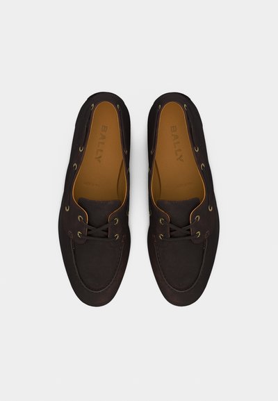 Ζευγάρι σκοτεινά καφέ δερμάτινα loafers με κορδόνια, ραφές moc toe και ταμπά εσωτερικές σόλες με την επωνυμία "BALLY", απεικονιζόμενα από πάνω σε λευκό φόντο.