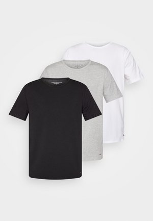 T-shirt en coton blanc avec une coupe décontractée et un col rond, mettant en avant un petit logo près de l'ourlet, associé à un short foncé.
