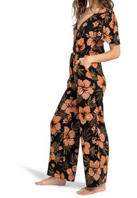Mono negro con estampado floral que presenta grandes patrones de hibisco en naranja y dorado, mangas cortas, un escote en V profundo y una cintura con lazo.
