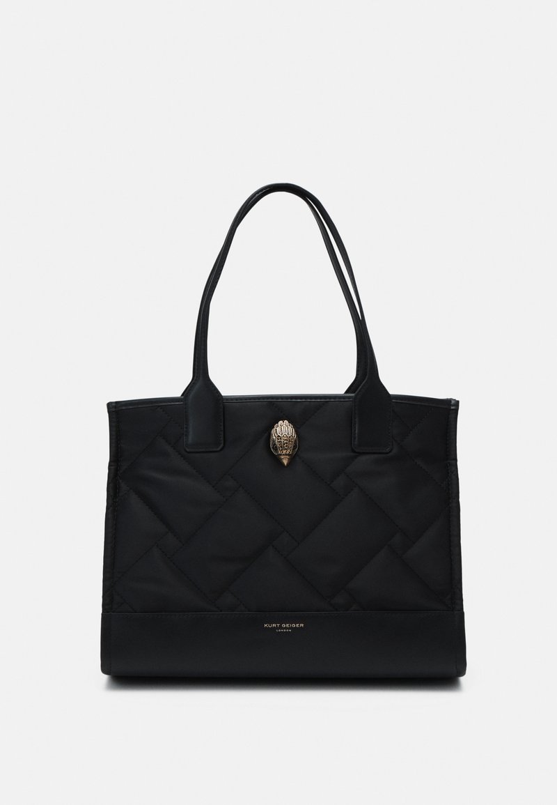 Borsa tote nera trapuntata con due manici, caratterizzata da un'emblema decorativo in oro e un logo alla base. Realizzata in tessuto e finta pelle.