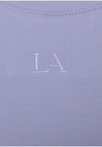 Lilac sleeveless top with a ribbed texture, featuring an embossed "LA" logo in white positioned centrally. Smooth fabric finish.