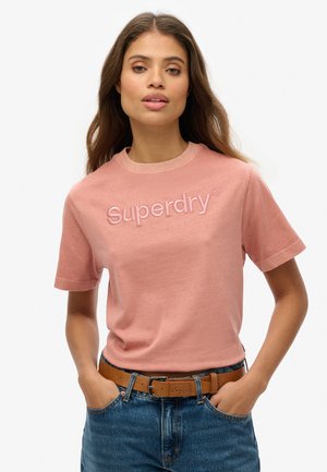 Roze katoenen t-shirt met een ribgebreide ronde hals en geborduurd "Superdry" logo op de borst. Gepaard met hoge taille denim shorts.