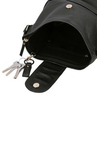 Borsa in pelle nera aperta con patta, che mostra l'interno vuoto e il portachiavi attaccato con quattro chiavi d'argento.