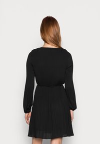 Czarna plisowana sukienka z długimi rękawami i cinched talią, charakteryzująca się gładką teksturą i skromnym, okrągłym dekoltem.