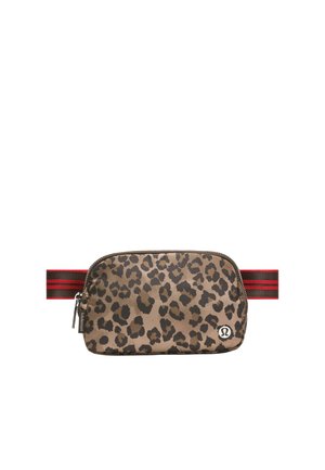 Pieni vyölaukku leopardin kuviolla, jossa on vetoketju, punamustaraidallinen säädettävä hihna ja hopeinen Lululemonin logo edessä.