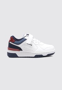 Zapatilla deportiva blanca con una correa de velcro, acentos en azul marino y burdeos, lados perforados y una suela de goma texturizada.
