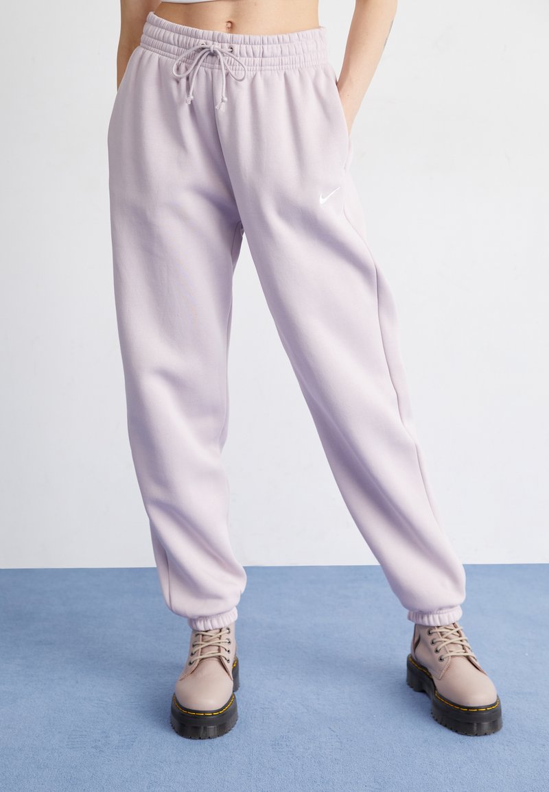 Lavendel Sweatpants mit elastischem Bund und Kordelzug, ausgestattet mit seitlichen Taschen. Kombiniert mit beigen Schnürstiefeln mit dicker Sohle und kontrastierender Sohle.