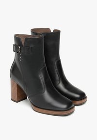 Schwarze Leder-Ankle-Boots mit runder Zehenform, einem Blockabsatz in mittlerer Höhe, seitlichem Reißverschluss und einem verstellbaren Schnallenakzent.