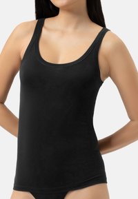 Top nero senza maniche realizzato in tessuto morbido. Presenta uno scollo rotondo, spalline larghe e una forma aderente. Texture liscia con dettagli di cucitura minimi.