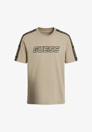 Beige T-shirt met korte mouwen en het GUESS-logo in het zwart aan de voorkant, met zwarte merkstrepen langs de schouders en mouwen.