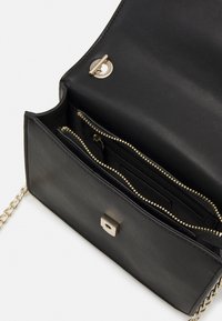 Black leather handbag with a smooth texture, featuring gold hardware, a square clasp closure, and multiple interior zippered compartments.