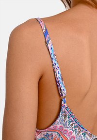 Costume da bagno multicolore con una scollatura bassa. Le bretelle presentano un motivo decorativo in rosa, blu e bianco con una chiusura metallica.