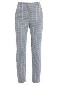 Pantaloni in tessuto a motivo coda di gallo in bianco e nero con strisce azzurro chiaro. Il tessuto appare liscio, con un design su misura e aderente.