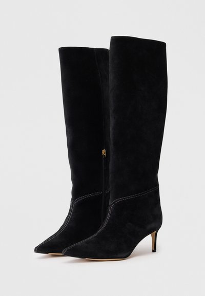 Μαύρες σουέτ μπότες μέχρι το γόνατο με μυτερή μύτη και μικρό τακούνι στιλέτο. Διαθέτουν φερμουάρ και αντίθετη ραφή.