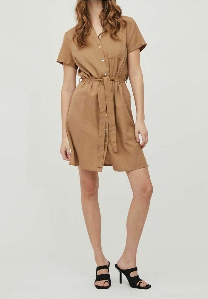 Robe courte à manches courtes avec devant boutonné, taille ceinturée, ourlet à hauteur du genou et coupe décontractée. Associée à des sandales à talons hauts noires.