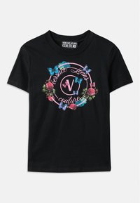 Svart T-skjorte med en fargerik blomster- og sommerfugl-grafikk, med rosa og blå aksenter. "Versace Jeans Couture" trykt i et sirkulært design.
