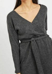 Šedé zavinovací šaty s dlouhými rukávy, výstřihem do V, opaskem v pase a měkkou strukturovanou tkaninou.