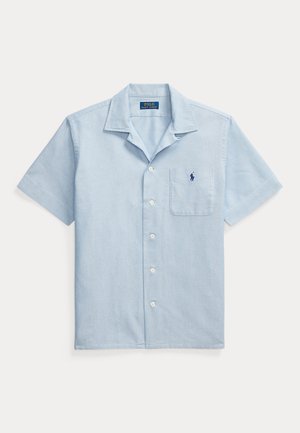 Šviesiai mėlyna trumpomis rankovėmis marškinėliai su mygtukais, kairėje krūtinės pusėje kišene ir išsiuvinėtu tamsiai mėlynu Polo Ralph Lauren logotipu.