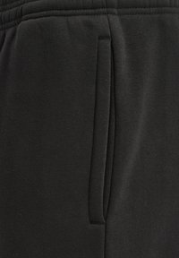 Schwarze Jogginghose aus weichem Material, mit Seitentaschen, elastischem Bund und flachen Nähten für zusätzlichen Komfort.
