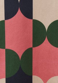 Textildruck mit großen sich überlappenden Kreisen in Grün, Pink und Marineblau auf einem beigen Hintergrund mit strukturierter Oberfläche.