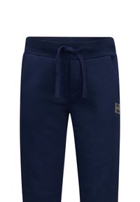 Marineblauwe katoenen joggers met een elastische tailleband en een trekkoord, en een klein label aan de voorkant. Soepele textuur, taps toelopend ontwerp.