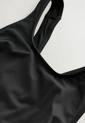 Čierny športový podprsenka vyrobená z hladkej, elastickej tkaniny s pretekárskym strihom a prešitými detailami po okrajoch.