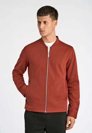 Rote Zip-Jacke mit Kragen, aus einem glatten, strukturierten Stoff gefertigt. Verfügt über Seitentaschen und eine taillierte Silhouette.