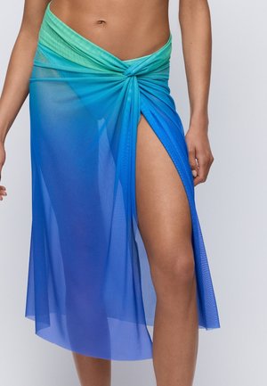 Doorschijnende, gradiënt sarong in blauw en groen, met een gedraaide knoop in de taille en een hoge split aan één zijde. Lichtgewicht stof.