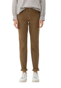 Brązowe, dopasowane spodnie z pięcioma kieszeniami i zapięciem na guzik, zestawione z białymi trampkami. Materiał wydaje się gładki z delikatnym połyskiem.