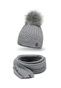 Berretto grigio a maglia con un pompon in pelliccia sopra e sciarpa abbinata. Entrambi presentano un design testurizzato e un piccolo tag in pelle con marchio.