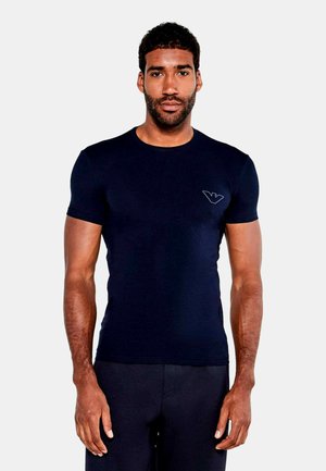 Tricou fitted bleu marin, confecționat dintr-un material neted, cu mâneci scurte, având un logo subtil brodat pe pieptul stâng.