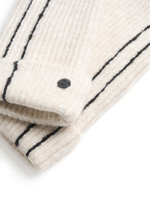 Pletenina boje kreme s vertikalnim rebrima, sa crnim prugama i crnim dugmetom na manžetama. Mekana tekstura.