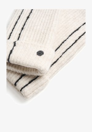 Îmbrăcăminte tricotată de culoare crem, cu nervuri verticale, având dungi negre și un detaliu cu un nasture negru la mansetă. Textură moale.